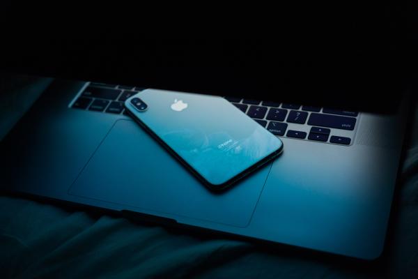 An iphone resting on a semi closed laptops keyboard. Photo by Dima Solomin on Unsplash