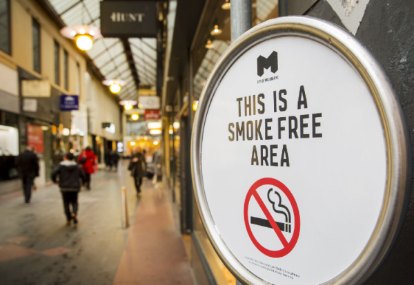 Smoke free area sign, imposed against a backdrop of Mebourne shops